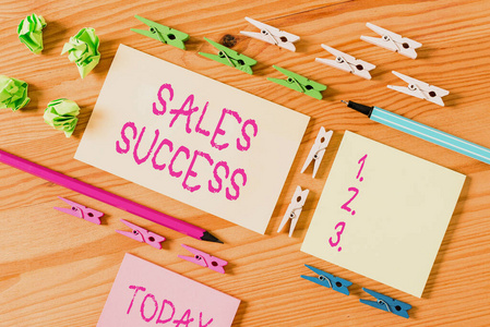 彩色衣夾放在木制地板中央的空矩形方形提醒紙條周圍。有凹槽和槽的木頭。辦公用品,鉛筆和鋼筆。